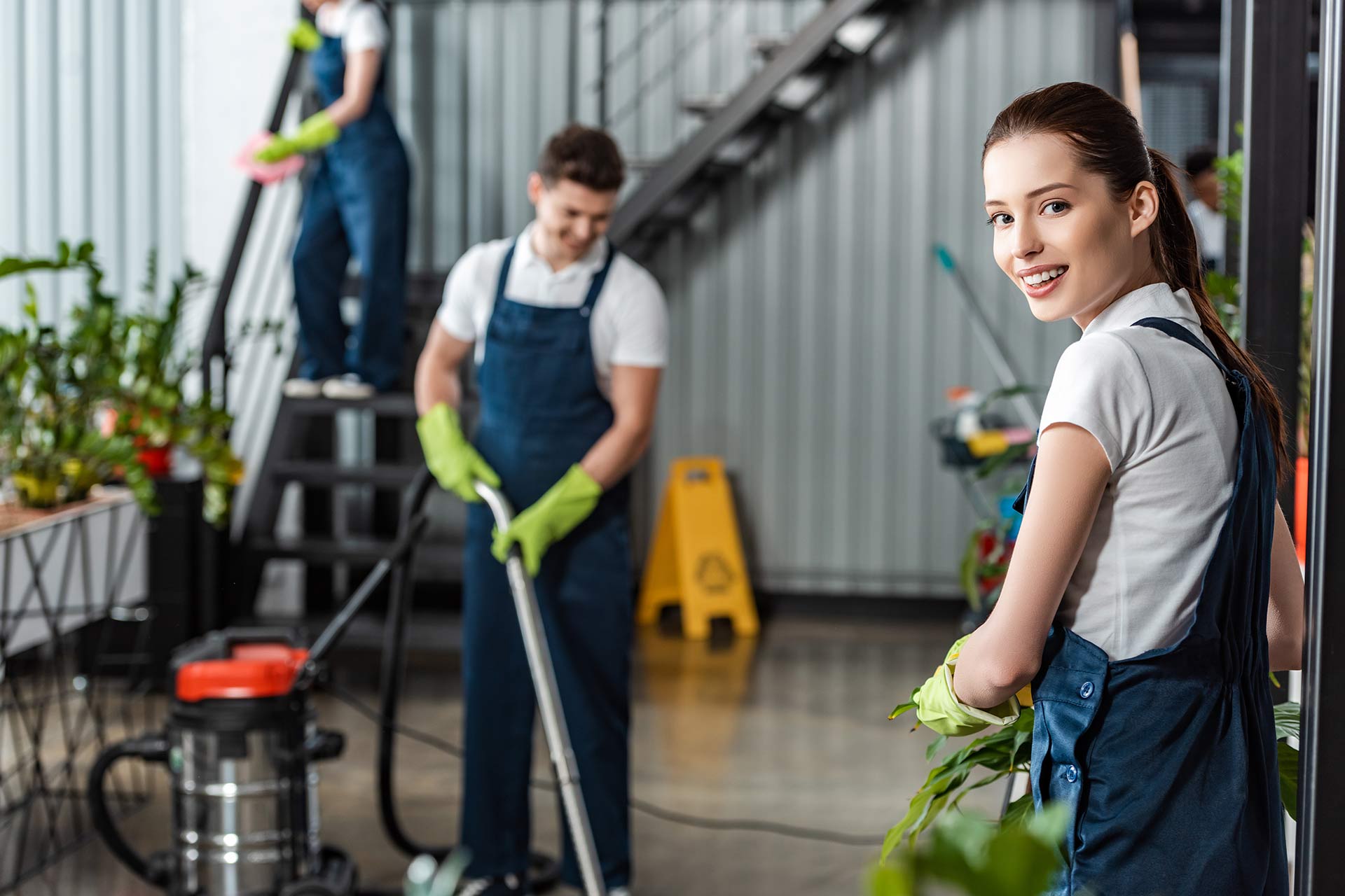 attractive cleaner smiling at camera while colleag 2024 11 18 00 05 27 UV5DXZC